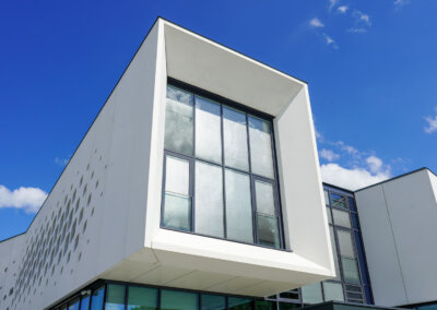 Modernes Firmengebäude der Stangl AG mit markanter weißer Fassade und großen Glasfenstern, Waldkraiburg.