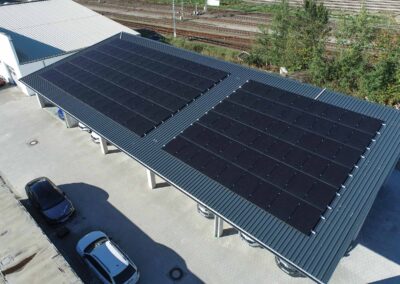 Dachansicht eines gewerblichen Photovoltaik-Carports mit schwarzen Solarpanelen auf einem Trapezblechdach.