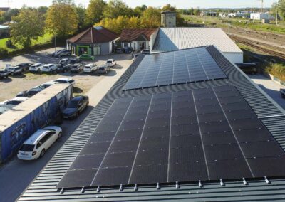 Große Photovoltaikanlage auf einem Trapezblechdach eines Autohauses, optimiert für gewerbliche Energieerzeugung.