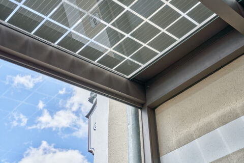 Detailansicht pulverbeschichteter Aluminiumprofile als Rahmen für ein transparentes Glasdach mit integrierten Photovoltaikmo…