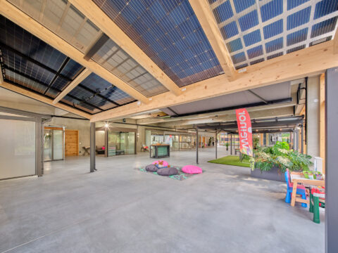 Moderner Carport oder überdachter Ausstellungsbereich mit integrierten Photovoltaik-Modulen und einer Holz-Aluminium-Konstru…