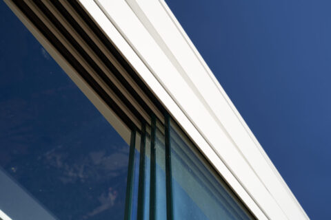 Detailansicht einer modernen Deckenschiene für ein transparentes Glasschiebesystem im Kaltwintergarten. Bietet optimalen Wet…