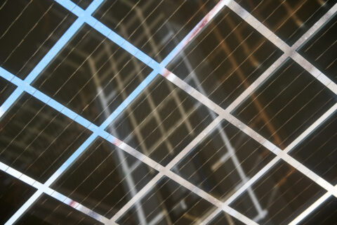 Nahaufnahme von durchgehenden Solarmodulen, die als transparente Terrassenüberdachung fungieren und effizient Sonnenenergie…