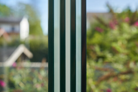 Nahaufnahme einer Einscheibensicherheitsglas Schiebeanlage von Sunparadise im Kaltwintergarten in Oberpframmern, mit verschw…