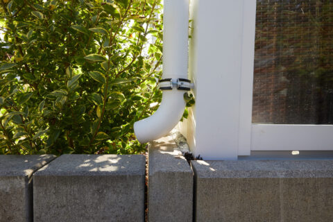 Weißes Fallrohr am Kaltwintergarten in Oberpframmern, entwässert die Terrasse effizient und zuverlässig.