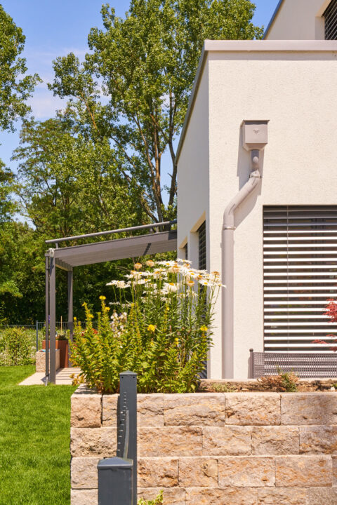 Moderne Aluminium-Terrassenüberdachung von Oberhauser Bau Systeme GmbH an einem Einfamilienhaus in Landshut, umgeben von gep…