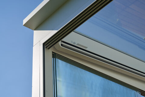 Detaillierte Ansicht der Aluminium-Führungsschiene einer Unterdachmarkise an einem Kaltwintergarten. Präzise Konstruktion.