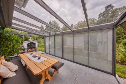 Moderner Kaltwintergarten mit Aluminium-Glas-Konstruktion, sichtbaren Sparren, integrierter Beschattung.