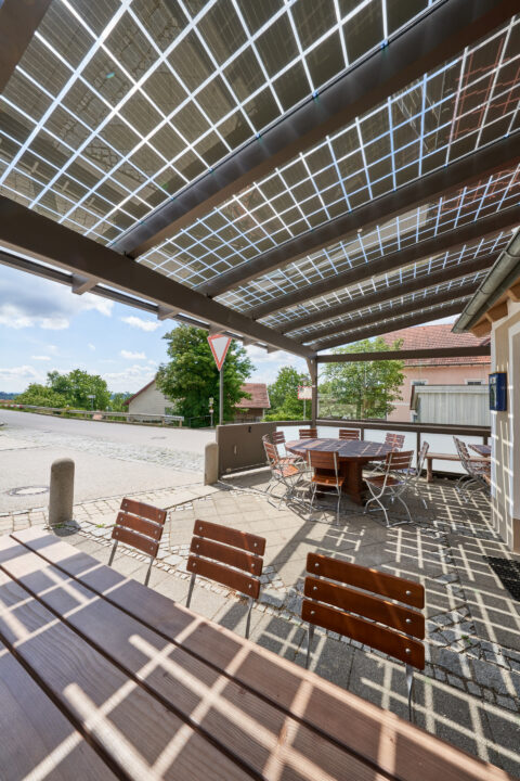 Terrassenüberdachung mit transparenten PV-Glasmodulen auf stabiler Aluminiumkonstruktion. Ideale Lösung für Gastronomie und…