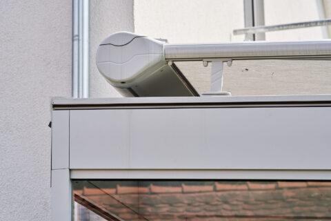 Weißer Markisenkasten RAL 9006 am Wintergarten, schützt die Glasstruktur in Zorneding effektiv vor Sonne.