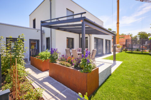 Freistehendes Terrassendach aus Aluminium mit transparentem Glasdach auf moderner Terrasse eines Einfamilienhauses in Landsh…