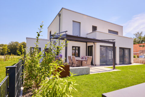 Modernes Einfamilienhaus mit stilvollem Aluminium-Terrassendach und gepflegter Gartengestaltung, realisiert von Oberhauser B…