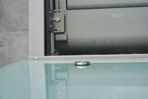 Nahaufnahme einer Balkonverglasung, Details der sicheren Befestigung von Glaselementen an Aluminiumprofilen.