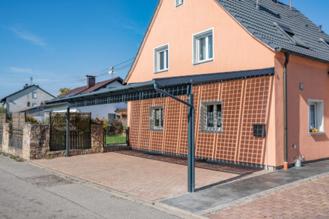 Photovoltaik-Carport aus Glasbau am privaten Einfamilienhaus in Mühldorf am Inn, bietet Wetterschutz und erzeugt Solarstrom…