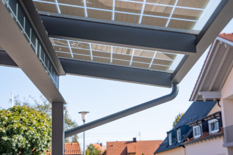 Detaillierte Ansicht eines modernen PV-Carports mit pulverbeschichtetem Aluminiumrahmen, integrierten Solarmodulen und Entwä…