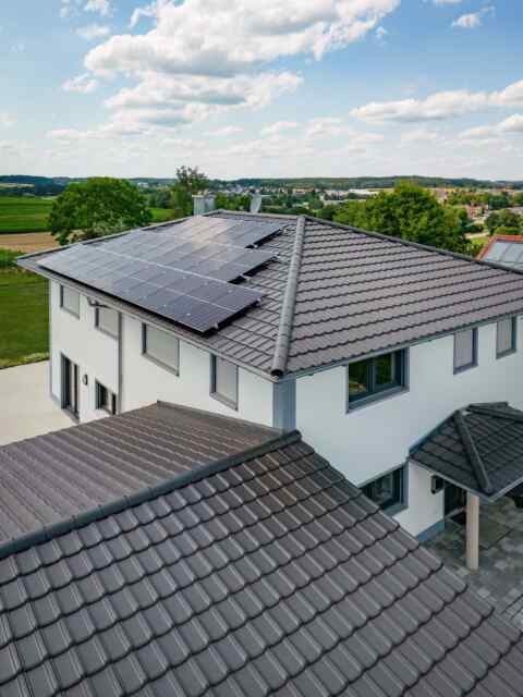 Moderne Photovoltaikanlage auf dem Dach eines weißen Einfamilienhauses in Neumarkt St. Veit, Mühldorf am Inn.