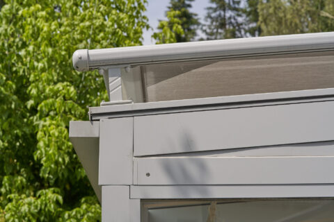 Detaillansicht einer modernen Regenrinne und integrierten Beschattung an einem Kaltwintergarten aus Glas in Zorneding.