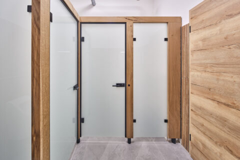 WC-Kabinen mit Milchglas und Echtholzrahmen, gefertigt von Oberhauser Bau Systeme GmbH für stilvolle Sanitäranlagen.