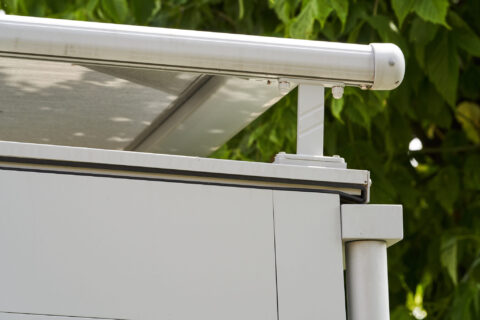 Detailansicht des seitlichen Führungsprofils einer weissen Weinor WGM Aufdachmarkise auf einem Wintergarten in Zorneding.