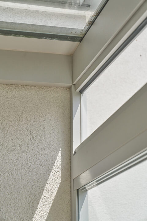 Detailansicht eines Kaltwintergartens mit seitlichem Oberlicht, Aluminiumrahmen und Glasflächen, angrenzend an eine struktur…