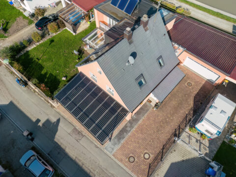 Luftbild eines Einfamilienhauses mit modernem Solar-Carport in Mühldorf, der PV-Module zur Energiegewinnung nutzt.
