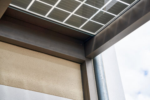Detaillierter Blick auf eine Solarterrasse mit integrierten Photovoltaikmodulen und robustem Aluminiumrahmen.