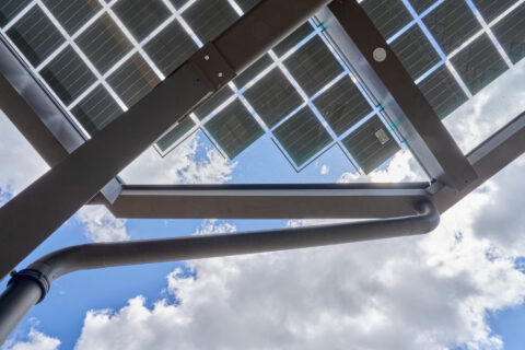 Filigrane Aluminiumstütze und integrierte Solarmodule eines Terrassendachs in Niederbergkirchen unter blauem Himmel.