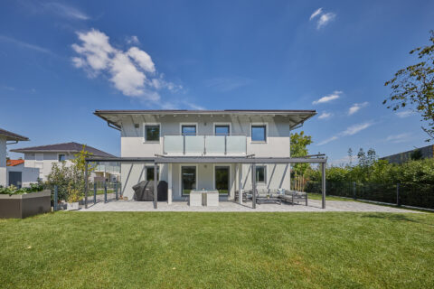 Moderne Terrassenüberdachung mit Glasschiebeelementen an einem Einfamilienhaus in Feldkirchen