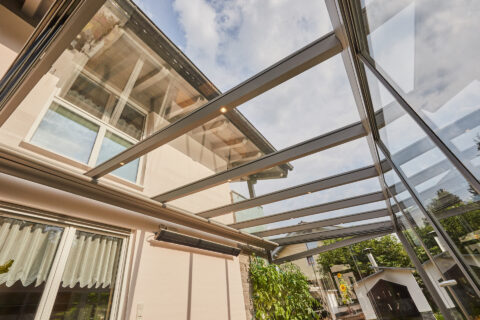Moderne Glas Terrassenüberdachung als stilvoller Kaltwintergarten mit seitlichen Schiebeanlagen am Einfamilienhaus Kolbermoor.