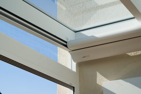 Weinor Unterdachmarkise in weißer Kassette, installiert unter Glasdach eines modernen Kaltwintergartens in Oberpframmern, bi…