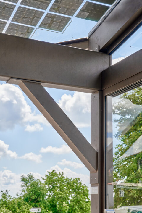 Detailansicht der robusten Aluminium-Unterkonstruktion eines Photovoltaik-Terrassendachs mit integrierten Solarmodulen und G…