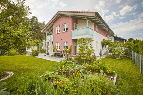 Modernes Wohnhaus mit filiigranem Kaltwintergarten und eleganten Glasbalkonen in Kolbermoor.