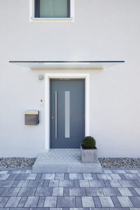 Modernes Eigenheim mit Vordachsystem Canopy über der anthrazitfarbenen Haustür.