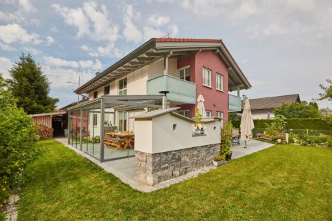 Moderner Kaltwintergarten aus Aluminium und Glas an einem Wohnhaus mit Garten in Kolbermoor.