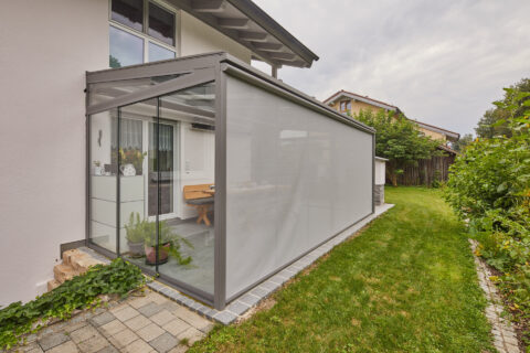 Moderner Kaltwintergarten mit Glasdach und integriertem Textil-Sonnenschutz an einem Einfamilienhaus in Rosenheim.