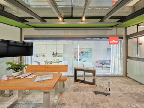 Grüne Unterdachmarkise im Pultdach-Wintergarten einer weinor Ausstellung, schafft mehr Raum und Licht.